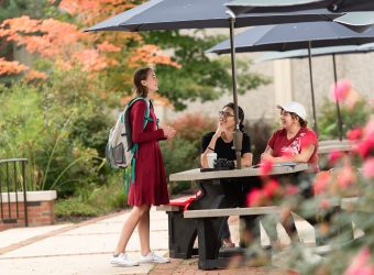 Students hanging out on Penny's Plaza outside of the Academic Center.